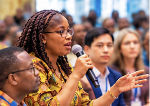 Church leader speaking into a microphone at the conference